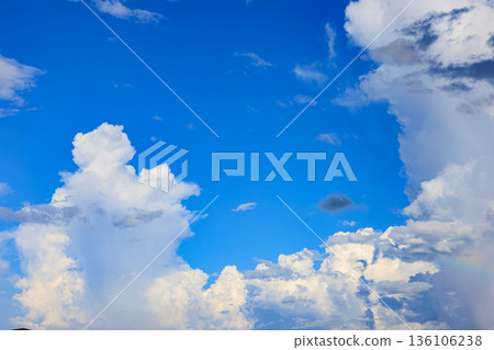 A rainbow appears in the summer blue sky and a huge cumulonimbus cloud A rainbow appears in the summer blue sky and a huge cumulonimbus cloud 136106238