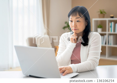一位正在使用電腦思考的女性 一位正在使用電腦思考的女性 136106254