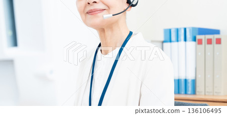 Senior woman working with an intercom Senior woman working with an intercom 136106495