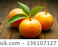 Fresh Orange Fruit with Green Leaves on Rustic Wooden Surface 136107127