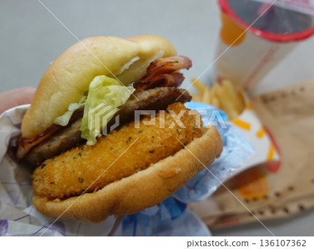A mouthwatering burger with a juicy patty, fresh lettuce, tomato, and melted cheese, all nestled in a soft bun. Perfect for food photography, showcasing the indulgence of classic comfort food. 136107362