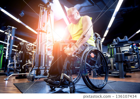 Disabled man training in the gym of rehabilitation center Disabled man training in the gym of rehabilitation center 136107434
