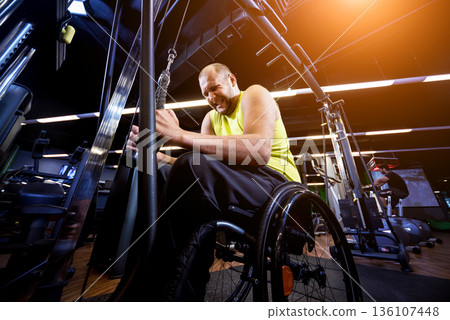 Disabled man training in the gym of rehabilitation center Disabled man training in the gym of rehabilitation center 136107448