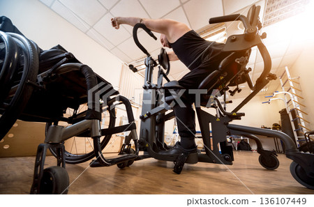 Disabled man training in the gym. Rehabilitation center Disabled man training in the gym. Rehabilitation center 136107449