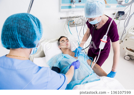 Doctors give resuscitation to a male patient in the emergency room. Doctors give resuscitation to a male patient in the emergency room. 136107599
