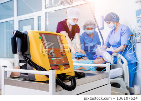 Doctors give resuscitation to a male patient in the emergency room. 136107624