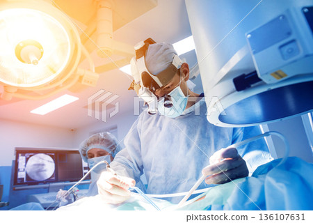 Spinal surgery. Group of surgeons in operating room with surgery equipment. Spinal surgery. Group of surgeons in operating room with surgery equipment. 136107631