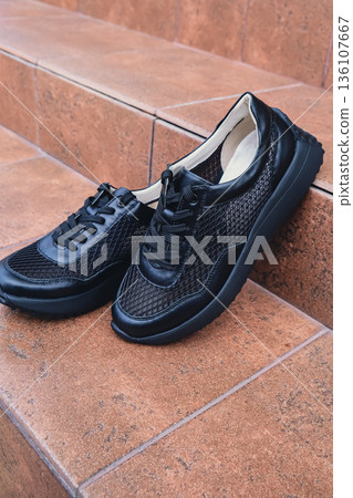 Elegant black leather womens shoes blank product for branding displayed. New casual female sneakers no-brand footwear e-commerce. No logo product 136107667
