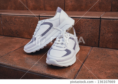 Fresh white leather sneakers without brand marks displayed. For design templates online shops and sustainability-themed marketing. Clean blank sneakers Fresh white leather sneakers without brand marks displayed. For design templates online shops and sustainability-themed marketing. Clean blank sneakers 136107669