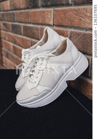 Fresh beige leather sneakers without brand marks displayed. For design templates online shops and sustainability-themed marketing. Clean blank sneakers 136107695