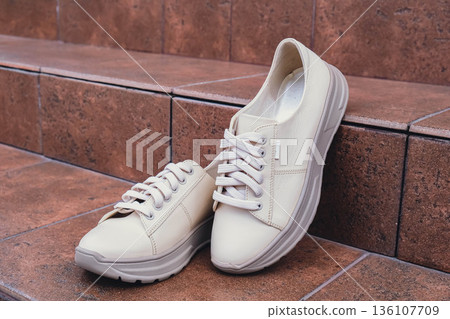 Fresh beige leather sneakers without brand marks displayed. For design templates online shops and sustainability-themed marketing. Clean blank sneakers Fresh beige leather sneakers without brand marks displayed. For design templates online shops and sustainability-themed marketing. Clean blank sneakers 136107709