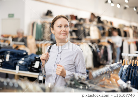 Adult woman walks through clothing store 136107740