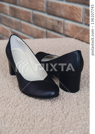 Elegant black leather womens shoes displayed. New black leather female shoes with glossy finish, perfect for style magazines footwear ads and modern elegant fashion e-commerce layouts. No logo 136107745