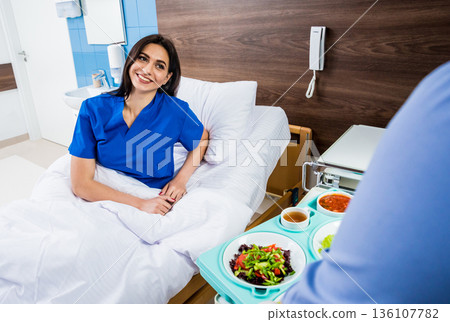 Nurse in medical coat is holding a tray with breakfast Nurse in medical coat is holding a tray with breakfast 136107782