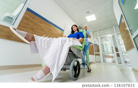 Nurse moves mobile medical chair with patient at hospital. Medical equipment. Nurse moves mobile medical chair with patient at hospital. Medical equipment. 136107833