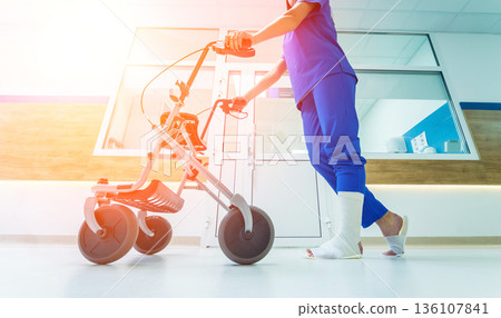 Patient on rollator with hand brakes moving in hospital Patient on rollator with hand brakes moving in hospital 136107841
