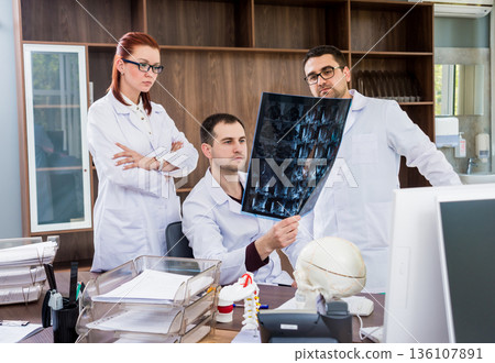 Doctors team having medical council in hospital. Discussing medical issues. Doctors team having medical council in hospital. Discussing medical issues. 136107891