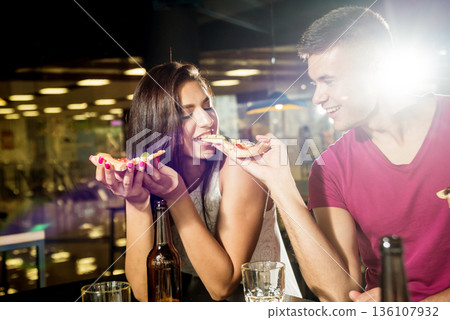 Cheerful friends in the pub. Drinking beer, eating pizza, talking, having fun. 136107932