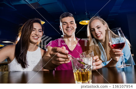 Cheerful friends in the pub. Drinking beer, wine and whisky Cheerful friends in the pub. Drinking beer, wine and whisky 136107954