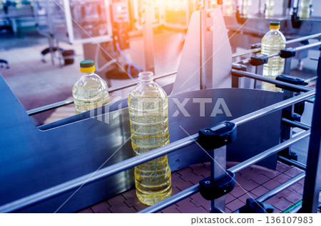 Bottling line of sunflower oil in bottles. Vegetable oil production plant. Bottling line of sunflower oil in bottles. Vegetable oil production plant. 136107983