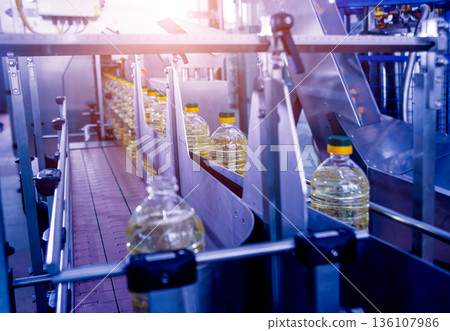 Bottling line of sunflower oil in bottles. Vegetable oil production plant. 136107986