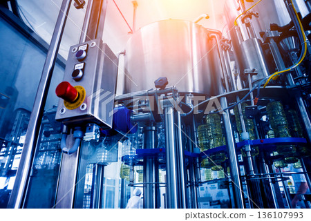 Bottling line of sunflower oil in bottles. Vegetable oil production plant. 136107993