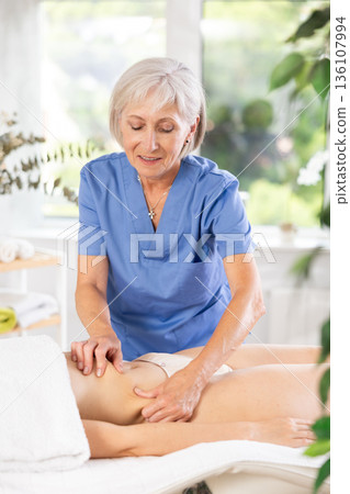 Elderly woman doing waist massage to young woman Elderly woman doing waist massage to young woman 136107994