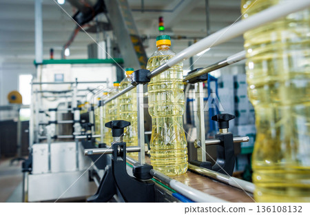 Bottling line of sunflower oil in bottles. Vegetable oil production plant. Bottling line of sunflower oil in bottles. Vegetable oil production plant. 136108132