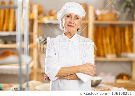 Portrait of professional mature female baker in white uniform in bakery 136108291