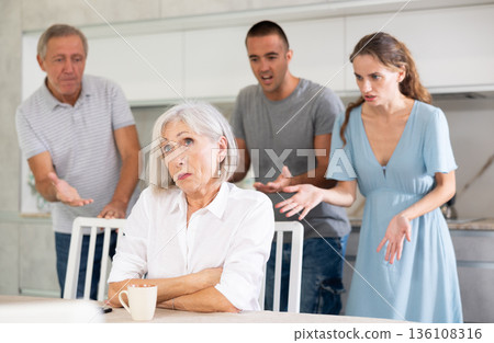 Portrait of thoughtful elderly woman who had conflict with his husband and adult children while cooking dinner in kitchen 136108316