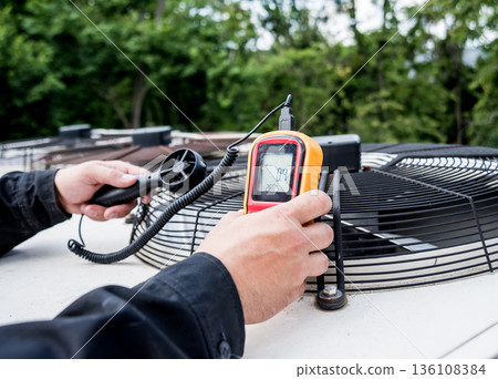 Technician use hand-held anemometer measuring air flowing measurement 136108384