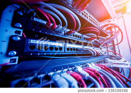 Network switch and ethernet cables in red and white colors. Data Center Network switch and ethernet cables in red and white colors. Data Center 136108386