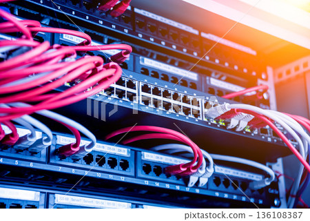 Network switch and ethernet cables in red and white colors. Data Center Network switch and ethernet cables in red and white colors. Data Center 136108387