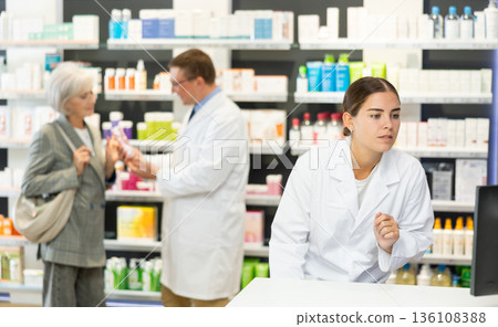 Girl pharmacist in pharmacy works with computer Girl pharmacist in pharmacy works with computer 136108388