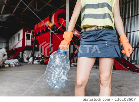 Woman-volunteer sorting trash at modern recycling plant. Separate garbage  136108607