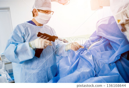 Arthroscope surgery. Orthopedic surgeons in teamwork in the operating room  136108644