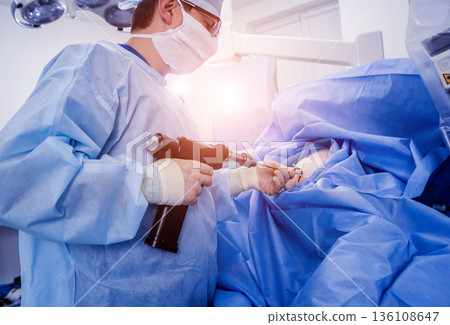 Arthroscope surgery. Orthopedic surgeons in teamwork in the operating room Arthroscope surgery. Orthopedic surgeons in teamwork in the operating room 136108647