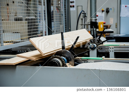 Production line of the wooden floor factory. CNC automatic woodworking machine. Production line of the wooden floor factory. CNC automatic woodworking machine. 136108801