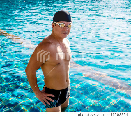 Young athletic man swimming in the swimming pool 136108854