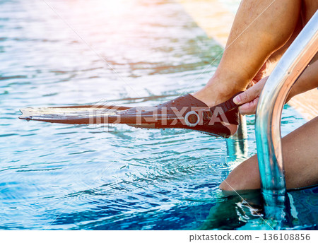 Young athletic man wearing flippers by the pool 136108856