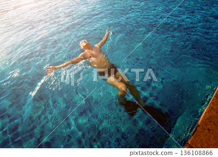 Young athletic man swimming in the swimming pool 136108866