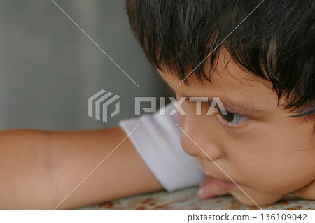 Closeup cute portrait of Asian little boy absent-minded 136109042