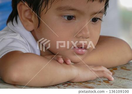Closeup cute portrait of Asian little boy absent-minded 136109100