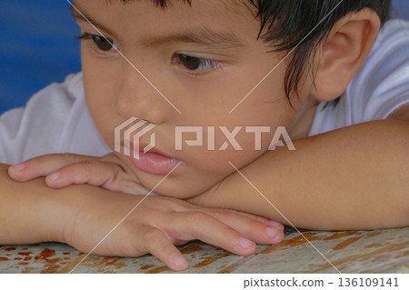 Closeup cute portrait of Asian little boy absent-minded 136109141