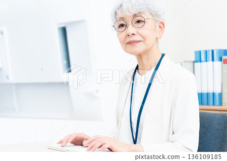 一位老年婦女正在使用電腦 136109185