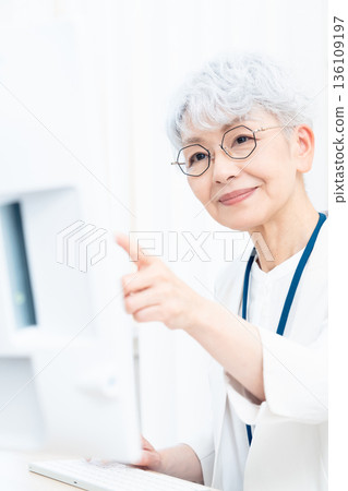 一位老年婦女正在使用電腦 136109197