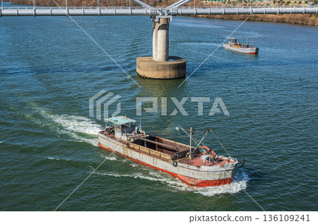 Gravel collection boat traveling up the Yodo River. View from Hirakata Bridge. Gravel collection boat traveling up the Yodo River. View from Hirakata Bridge. 136109241
