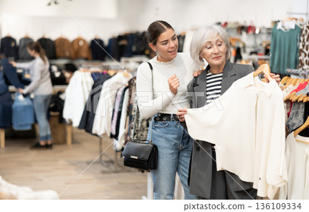 Elderly and young women choosing coat in store Elderly and young women choosing coat in store 136109334