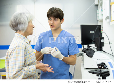 Professional male veterinarian communicates with alarmed senior female owner of pet Professional male veterinarian communicates with alarmed senior female owner of pet 136109346