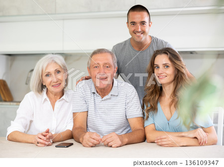 Family of four sitting in kitchen 136109347